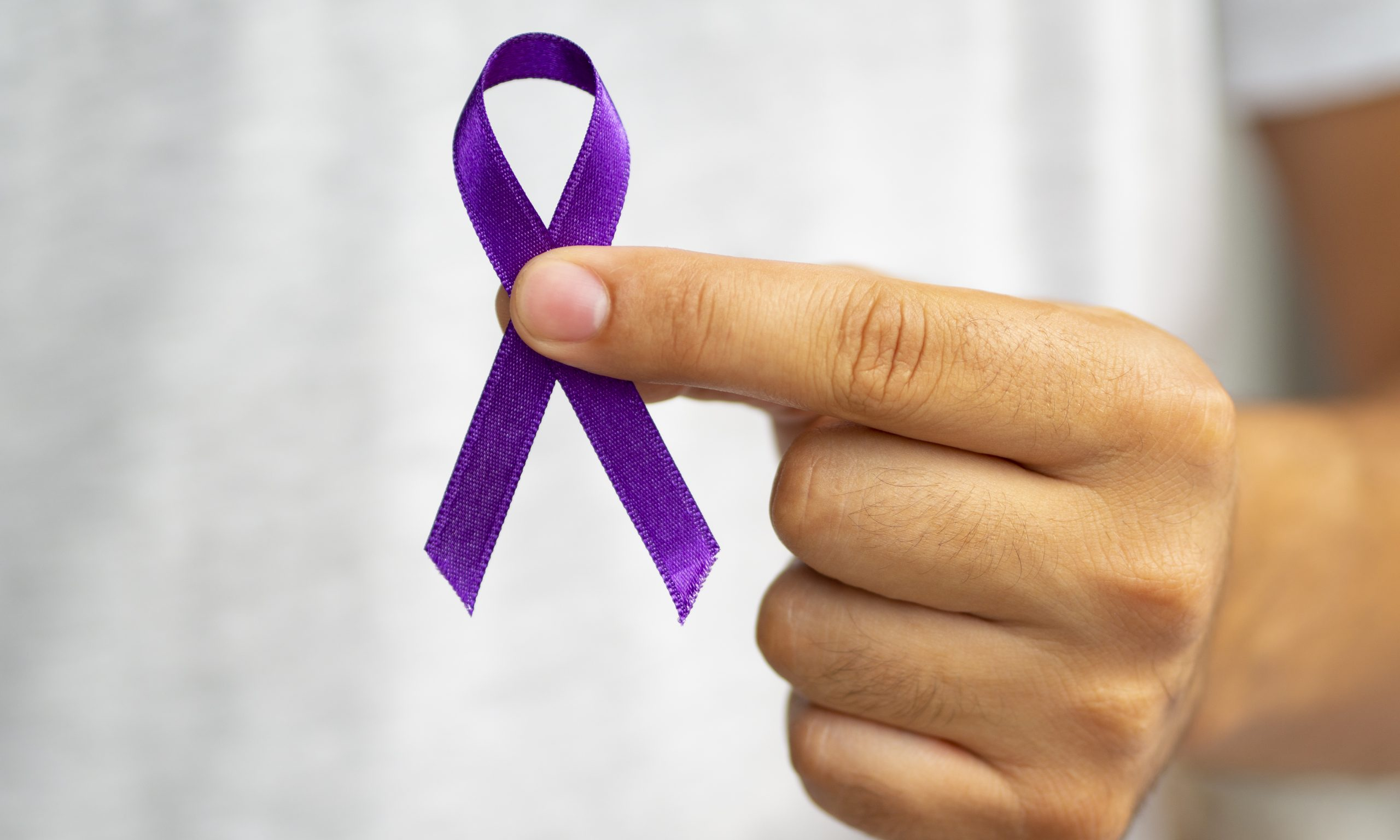 close-up-person-holding-up-purple-ribbon-scaled.jpg